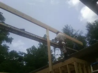 Carpenter setting a ridge beam over a new addition frame — Ice Dam Removal by Roofing Brothers in South Pomfret
