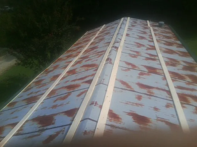 Rusted metal roof panels with new wood purlins before replacement — Storm Damage Roof Repair in South Pomfret by Roofing Brothers