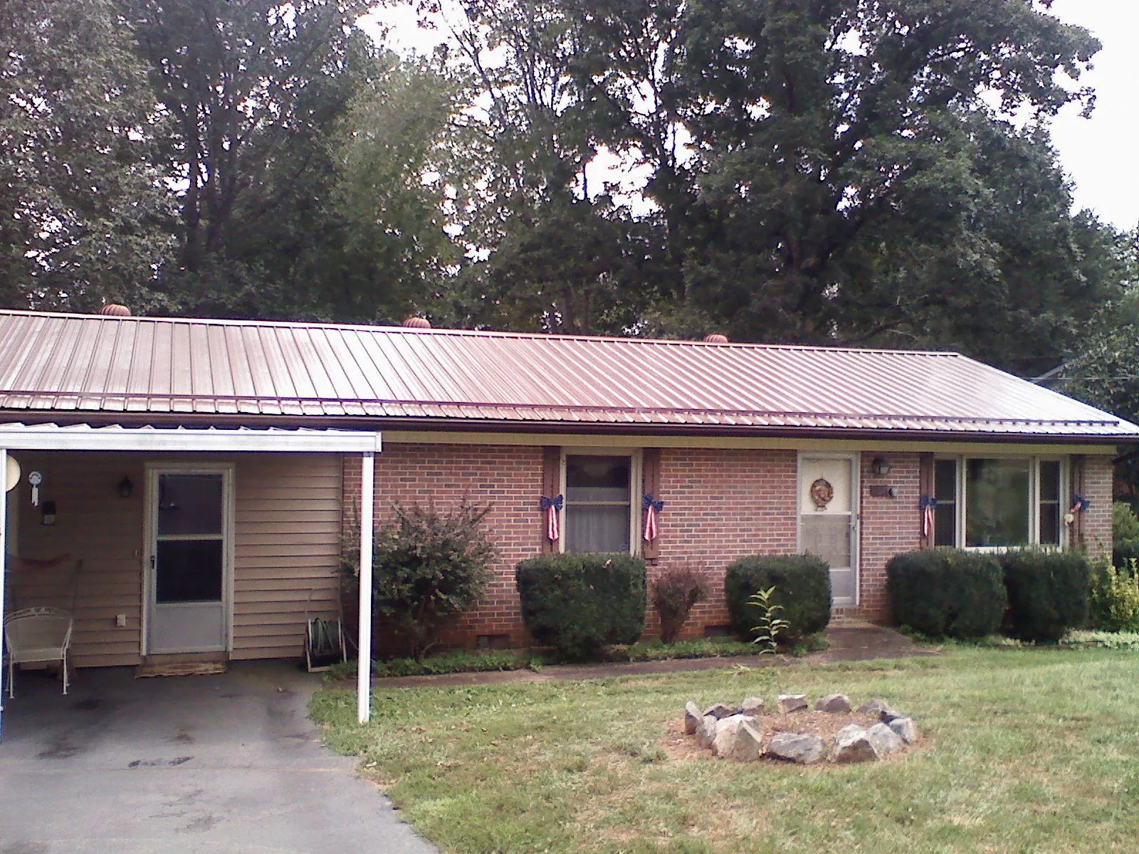 Bronze metal roof and carport on a brick ranch home — Roof Repair work by our crew in South Pomfret